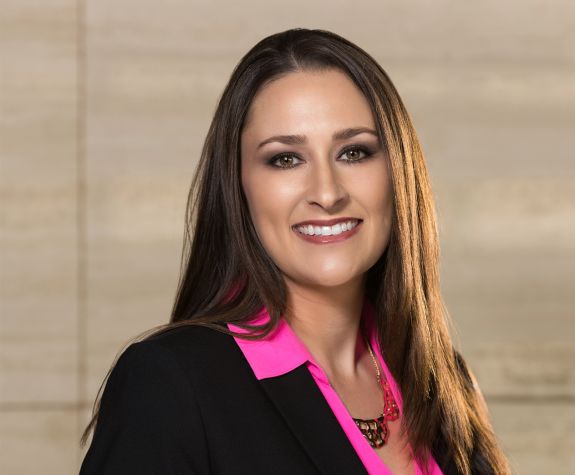 A woman in a suit poses for a photo
